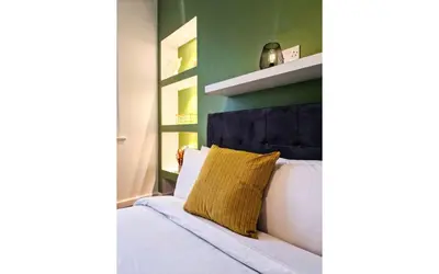 a bedroom with a white bed with a yellow pillow at Lodginet Stays - County Luxe - 2BR Flat 1 in Liverpool