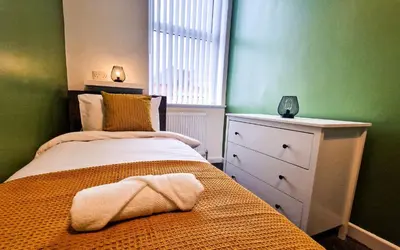 a bedroom with a bed and a dresser and a window at Lodginet Stays - County Luxe - 2BR Flat 1 in Liverpool