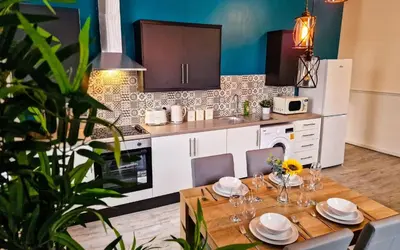 a kitchen with a wooden table and a dining room at Lodginet Stays - County Luxe - 2BR Flat 1 in Liverpool