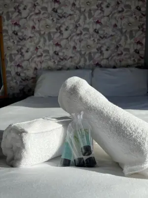 a pair of white towels and a bottle on a bed at No1 Lord street in Blackpool