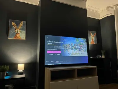 a flat screen tv sitting on a stand in a room at Breck House, 10 Mins to City Centre 5 Min Walk to Anfield Stadium in Liverpool