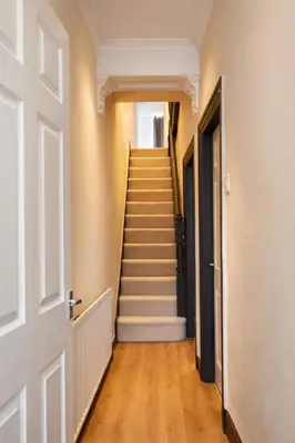 an empty hallway with stairs in a house at Breck House, 10 Mins to City Centre 5 Min Walk to Anfield Stadium in Liverpool
