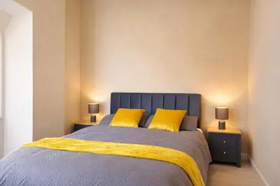 a bedroom with a blue bed with two yellow pillows at Breck House, 10 Mins to City Centre 5 Min Walk to Anfield Stadium in Liverpool