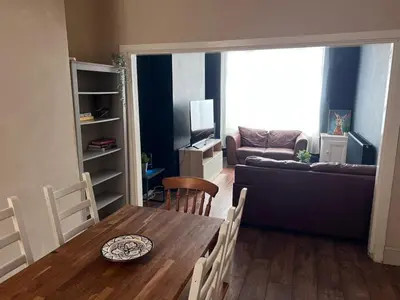 a living room with a table and a couch at Breck House, 10 Mins to City Centre 5 Min Walk to Anfield Stadium in Liverpool