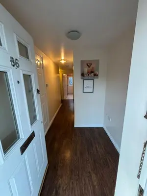 a hallway of a home with white walls and wood floors at EC Prime Home - Wigan, UK in Ince-in-Makerfield