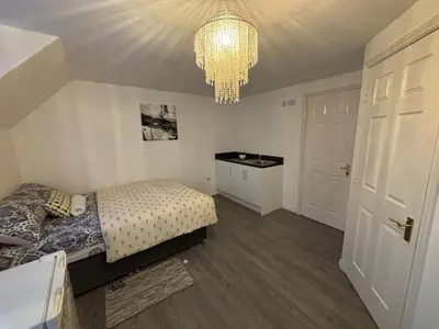 a bedroom with a bed and a chandelier at EC Prime Home - Wigan, UK in Ince-in-Makerfield