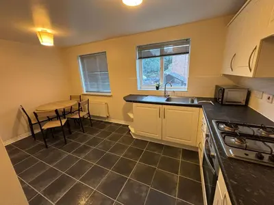 a kitchen with a table and a sink and a counter at EC Prime Home - Wigan, UK in Ince-in-Makerfield