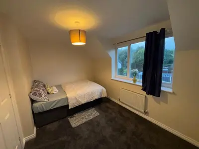 a small bedroom with a bed and a window at EC Prime Home - Wigan, UK in Ince-in-Makerfield