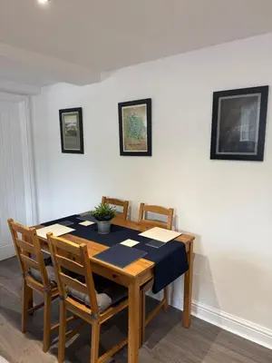 a dining room with a wooden table and chairs at Apartment 15 mins to Lake District & BAE Systems in Dalton in Furness