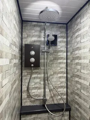a shower in a bathroom with a brick wall at Apartment 15 mins to Lake District & BAE Systems in Dalton in Furness