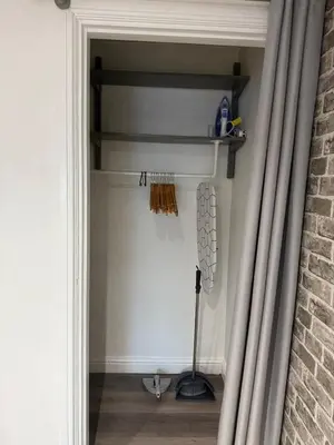 a door into a room with a shelf and a broom at Apartment 15 mins to Lake District & BAE Systems in Dalton in Furness