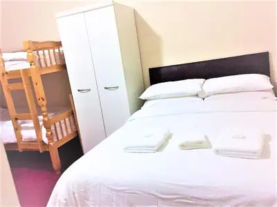 a bedroom with a white bed and a white cabinet at Lyndhurst Hotel in Blackpool