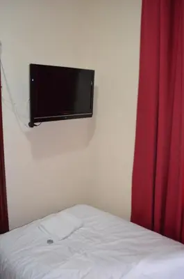 a bedroom with a bed and a flat screen tv on a wall at Lyndhurst Hotel in Blackpool