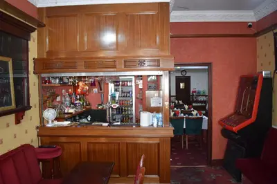 a bar in a restaurant with a counter and a bar at Lyndhurst Hotel in Blackpool