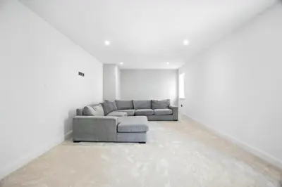 a living room with a gray couch in a white room at Fell View & Beaufort House in Preston