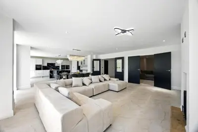 a living room with a white couch and a kitchen at Fell View & Beaufort House in Preston