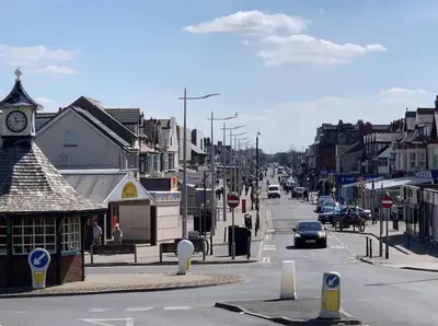 a city street with cars driving down the street at Beach Apartments in Cleveleys