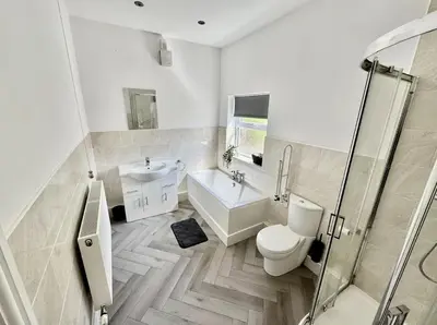 a bathroom with a toilet and a sink and a shower at Beach Apartments in Cleveleys