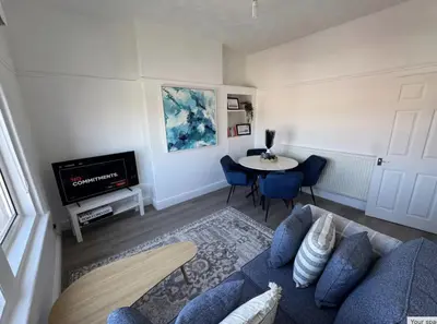 a living room with a blue couch and a table at Beach Apartments in Cleveleys