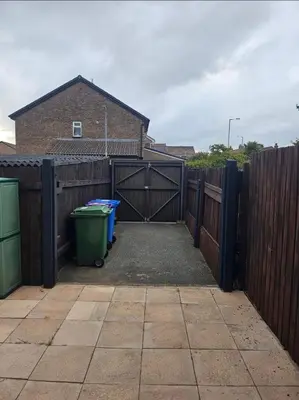 a driveway with a gate and a trash can in a fence at Self-contained 1 bedroom flat in Liverpool