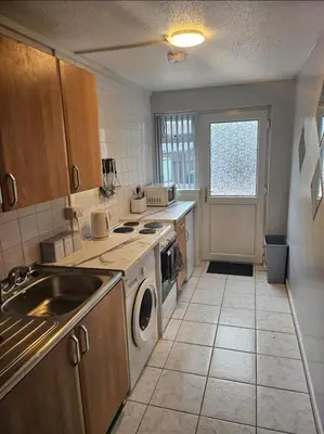 a kitchen with a sink and a washer and dryer at Self-contained 1 bedroom flat in Liverpool