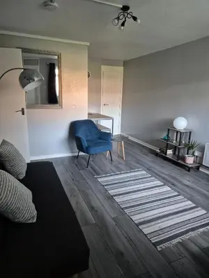 a living room with a blue chair and a table at Self-contained 1 bedroom flat in Liverpool