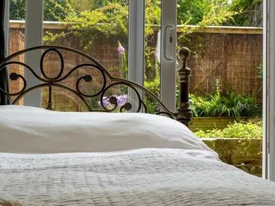 a bed with a white comforter in front of a window at Pass the Keys Bright Town-Centre Flat with Outdoor Area in Ulverston