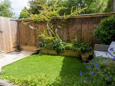 a small garden with a fence and grass at Pass the Keys Bright Town-Centre Flat with Outdoor Area in Ulverston