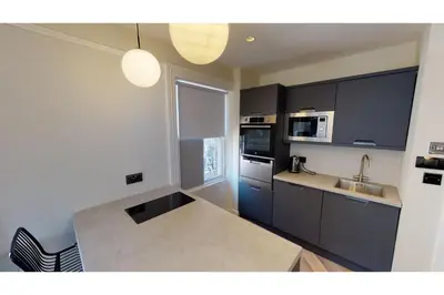 a kitchen with black cabinets and a sink at 2 Mins to Cathedral Georgian Quarter CityBreak in Liverpool