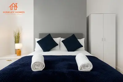 a bedroom with a blue and white bed with towels on it at 4 Bed near Anfield Stadium-Perfect for Groups & Contractors in Liverpool
