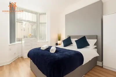 a bedroom with a large bed and a window at 4 Bed near Anfield Stadium-Perfect for Groups & Contractors in Liverpool
