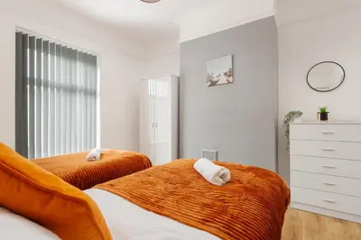a bedroom with two beds and a dresser at 4 Bed near Anfield Stadium-Perfect for Groups & Contractors in Liverpool