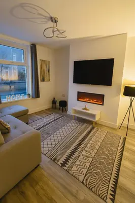 a living room with a couch and a flat screen tv at New Stylish Modern Home & Free Parking! in Darwen