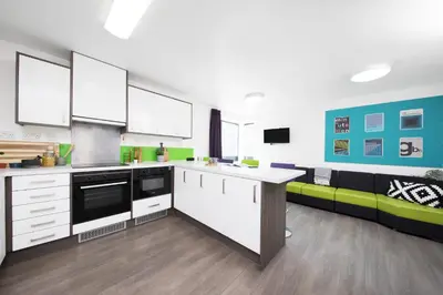 a kitchen with white cabinets and a green couch at Student Only Ensuite at Prospect Point Liverpool in Liverpool