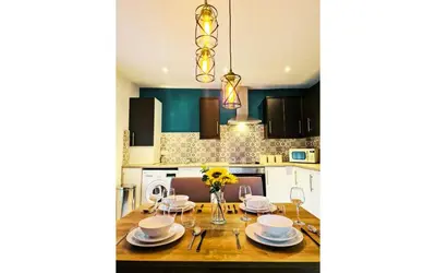 a kitchen with a table with chairs and a dining room at Lodginet Stays - County Heights - 2BR Flat 3 in Liverpool