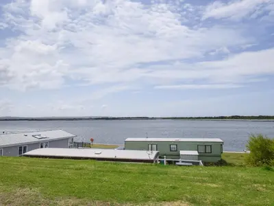 a house on the shore of a body of water at Coastal Comfort in Millom