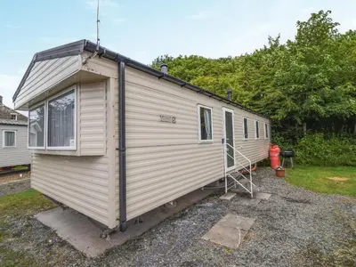 a white tiny house sitting in a yard at Coastal Comfort in Millom