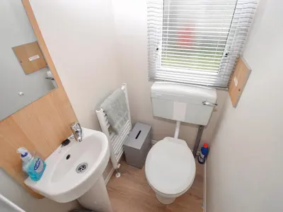 a small bathroom with a toilet and a sink at Coastal Comfort in Millom