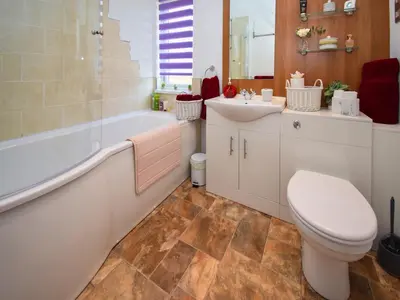 a bathroom with a toilet and a tub and a sink at Sunnybank in Warton