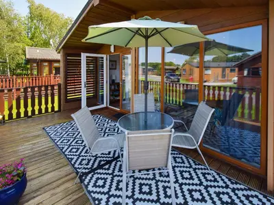 a patio with a table and chairs and an umbrella at Sunnybank in Warton