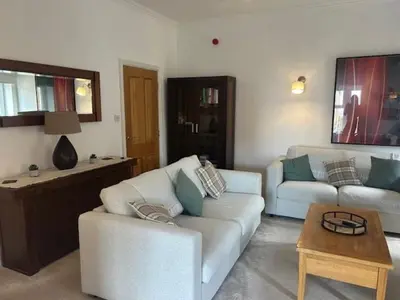a living room with two couches and a table at St Annes Spacious Apartment in Saint Annes on the Sea