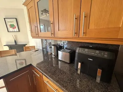 a kitchen with a counter with a stove and cabinets at St Annes Spacious Apartment in Saint Annes on the Sea