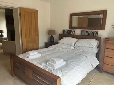 a bedroom with a large bed with towels on it at St Annes Spacious Apartment in Saint Annes on the Sea
