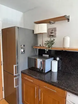 a kitchen with a refrigerator and a microwave at St Annes Spacious Apartment in Saint Annes on the Sea
