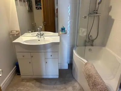 a bathroom with a sink and a bath tub and a sink at St Annes Spacious Apartment in Saint Annes on the Sea