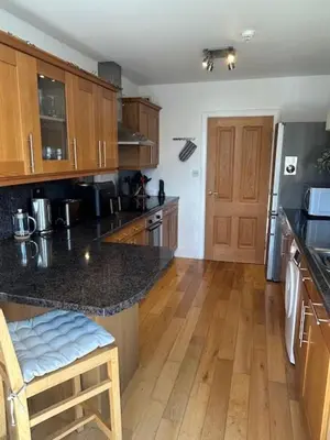 a kitchen with wooden cabinets and a counter top at St Annes Spacious Apartment in Saint Annes on the Sea