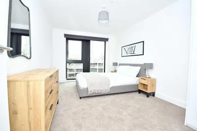 a white bedroom with a bed and a mirror at Bright Spacious 2 Bedroom Apartment in Liverpool in Liverpool