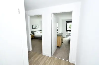 a white room with a bed and a mirror at Bright Spacious 2 Bedroom Apartment in Liverpool in Liverpool