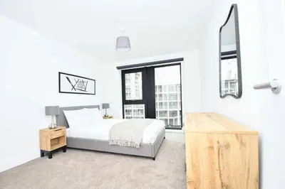 a white bedroom with a bed and a window at Bright Spacious 2 Bedroom Apartment in Liverpool in Liverpool