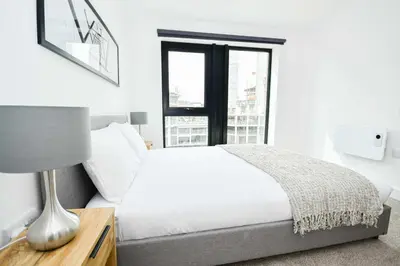 a white bedroom with a bed and a window at Bright Spacious 2 Bedroom Apartment in Liverpool in Liverpool